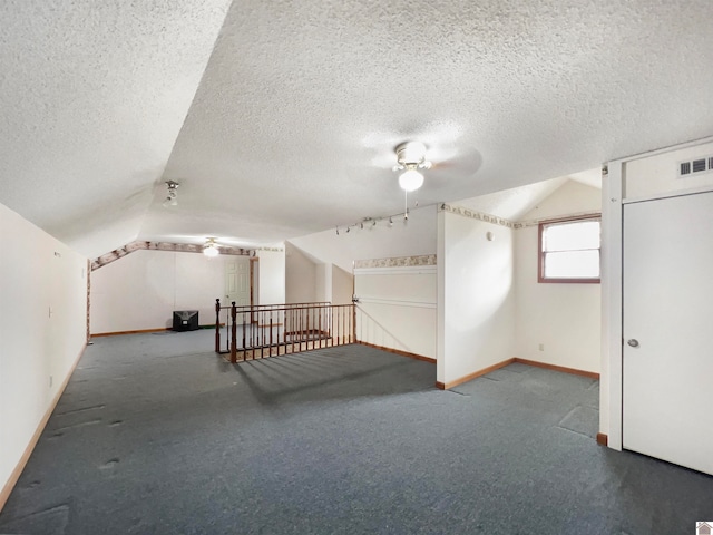 additional living space featuring ceiling fan, carpet flooring, a textured ceiling, and lofted ceiling