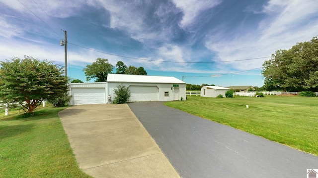 view of front facade with a detached garage, an outdoor structure, and a front yard