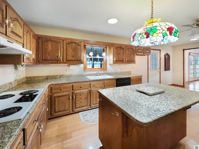 kitchen with a kitchen island, hanging light fixtures, white stovetop, sink, and light hardwood / wood-style floors