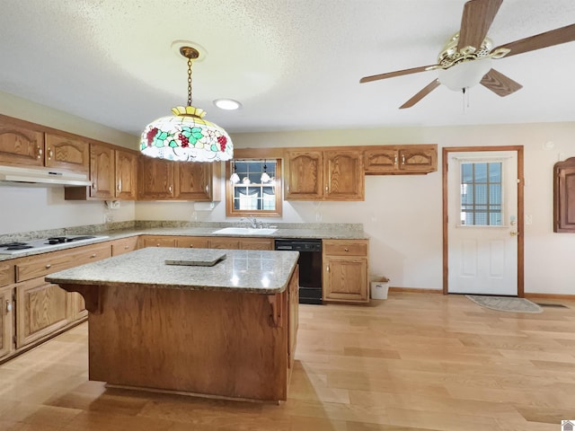 kitchen featuring white cooktop, a sink, under cabinet range hood, black dishwasher, and light wood-style flooring