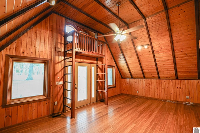 bonus room with light hardwood / wood-style flooring, wood ceiling, wood walls, and lofted ceiling with beams