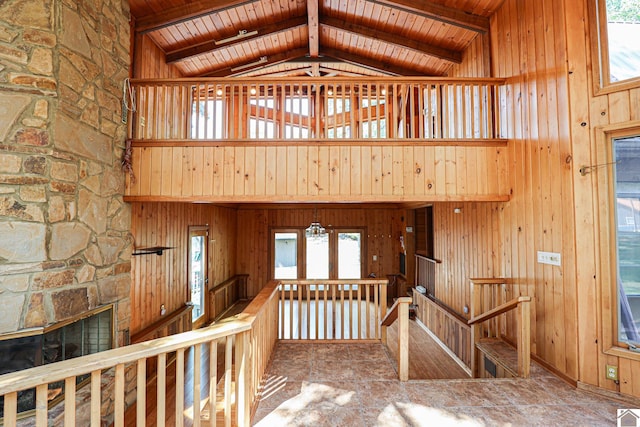 corridor featuring beam ceiling, wood ceiling, high vaulted ceiling, and wood walls