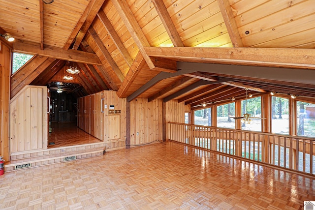 interior space with parquet flooring, lofted ceiling with beams, wooden ceiling, and wood walls