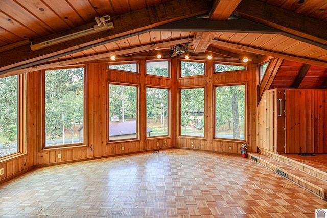 unfurnished living room with light parquet flooring, wood ceiling, wood walls, and vaulted ceiling with beams