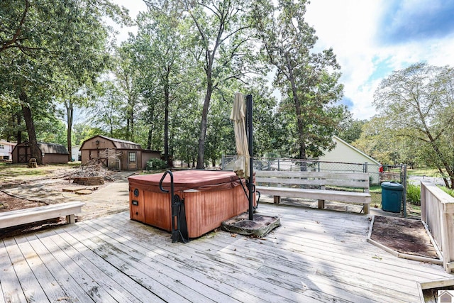 deck featuring a hot tub and an outbuilding