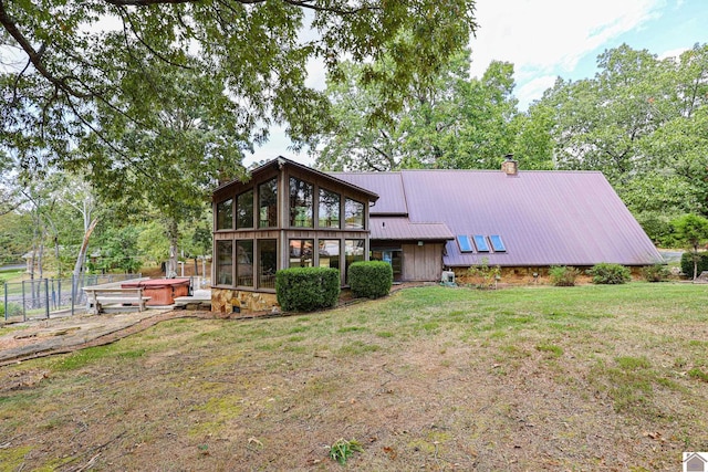 back of house featuring a yard and a sunroom