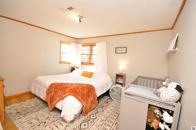 bedroom featuring crown molding and light hardwood / wood-style floors