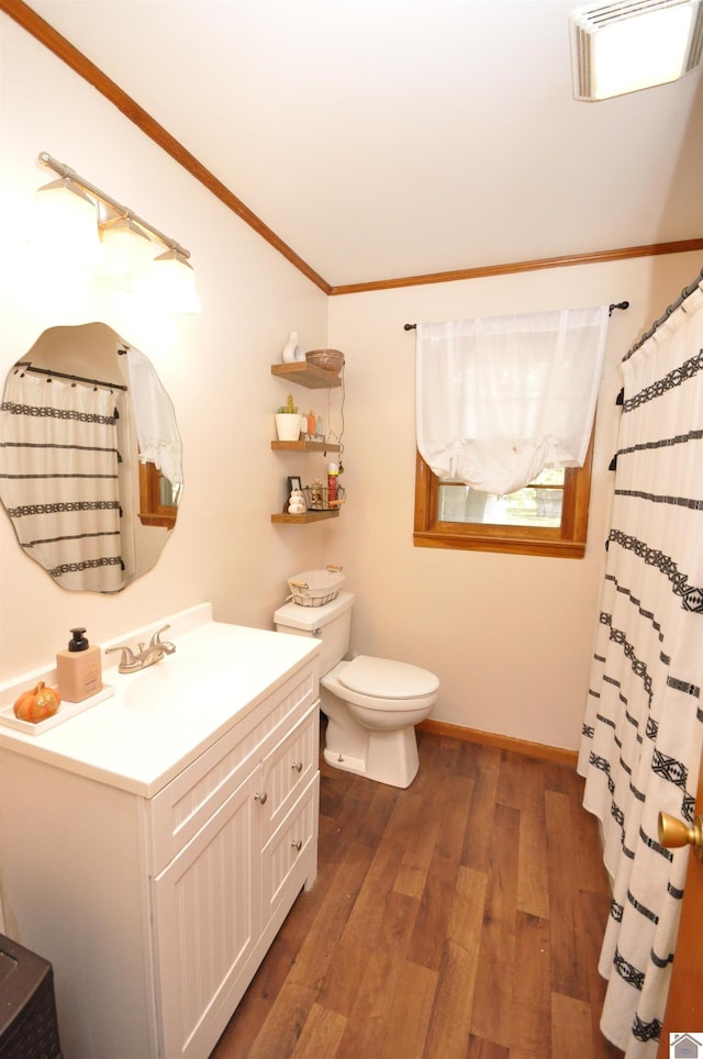 bathroom with vanity, crown molding, hardwood / wood-style flooring, and toilet