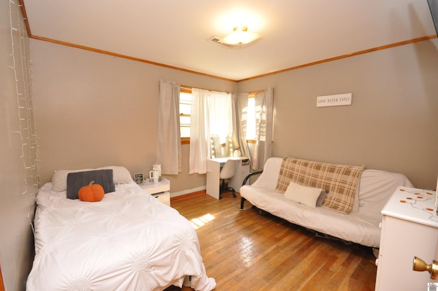 bedroom featuring ornamental molding and hardwood / wood-style floors