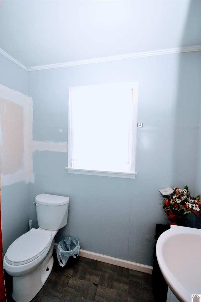 bathroom with hardwood / wood-style flooring, toilet, and crown molding