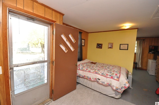 carpeted bedroom featuring wooden walls