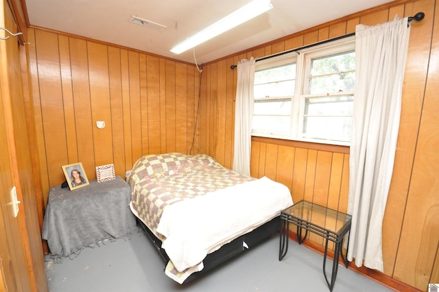 bedroom with wood walls and concrete flooring