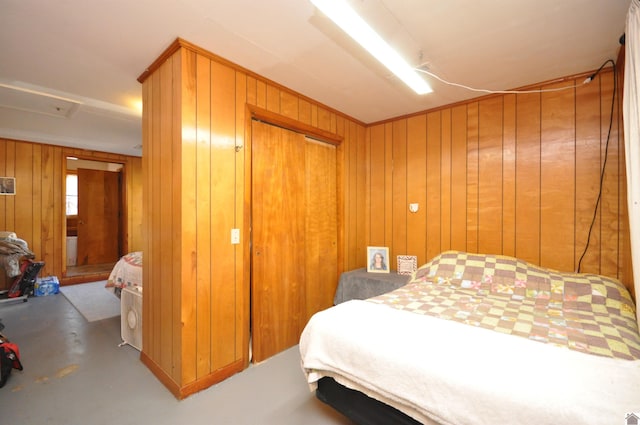 bedroom featuring concrete floors, a closet, wooden walls, and ceiling fan