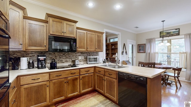 kitchen with light hardwood / wood-style flooring, black appliances, sink, crown molding, and decorative light fixtures