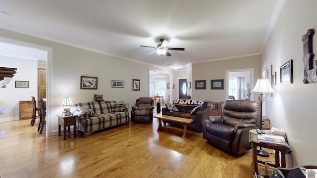 living room with ornamental molding, light wood-type flooring, and ceiling fan