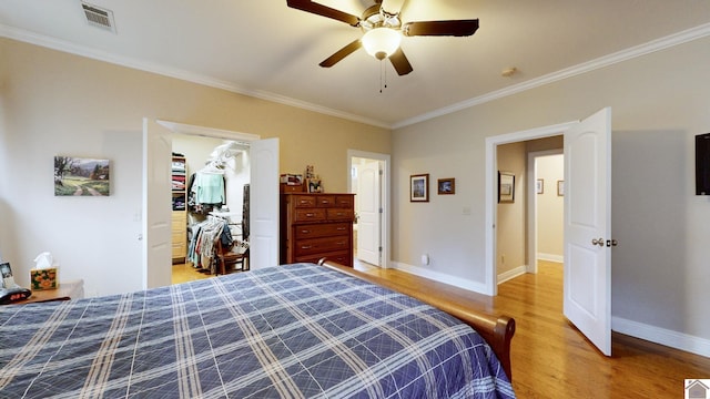 bedroom with ornamental molding, hardwood / wood-style flooring, a closet, and ceiling fan