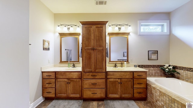 bathroom with vanity and tiled tub