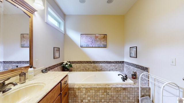 bathroom with vanity and a relaxing tiled tub