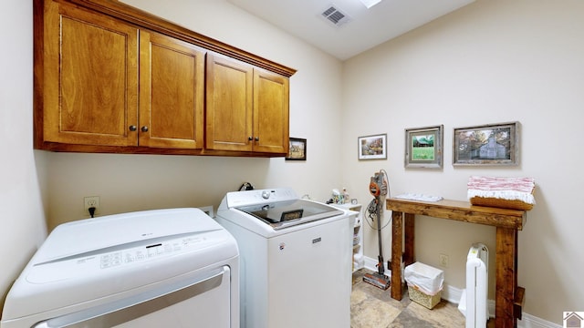 clothes washing area with washer and dryer and cabinets