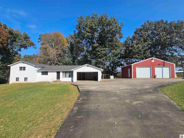 ranch-style home featuring a front yard, an outbuilding, and a garage