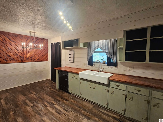 kitchen featuring wood walls, sink, dishwasher, wood counters, and decorative light fixtures