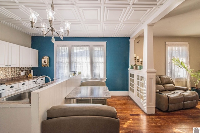 kitchen with decorative light fixtures, a healthy amount of sunlight, sink, and dark hardwood / wood-style flooring