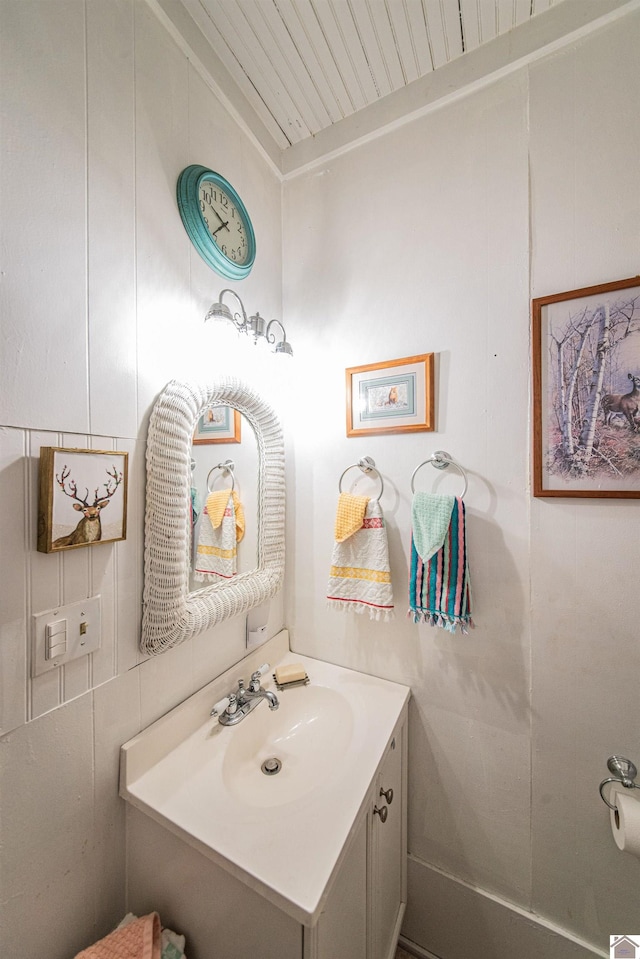 bathroom with vanity, ornamental molding, and tile walls