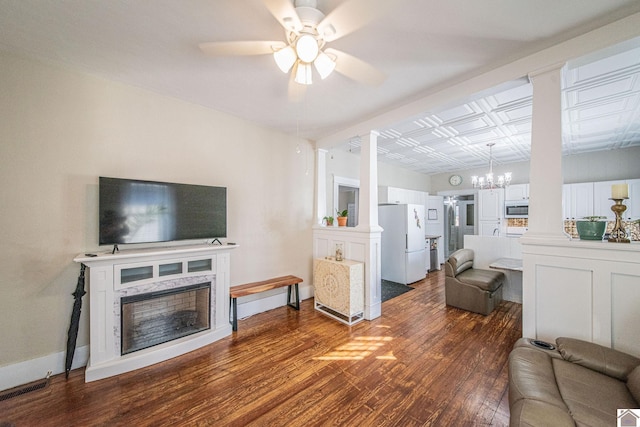 living room with dark wood-type flooring and ceiling fan with notable chandelier