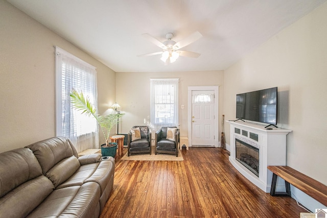 living room with dark wood-type flooring and ceiling fan