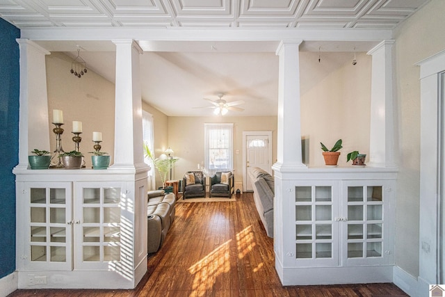 hall with crown molding, ornate columns, and dark hardwood / wood-style floors