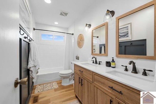 full bathroom with vanity, shower / bath combo with shower curtain, wood-type flooring, and toilet