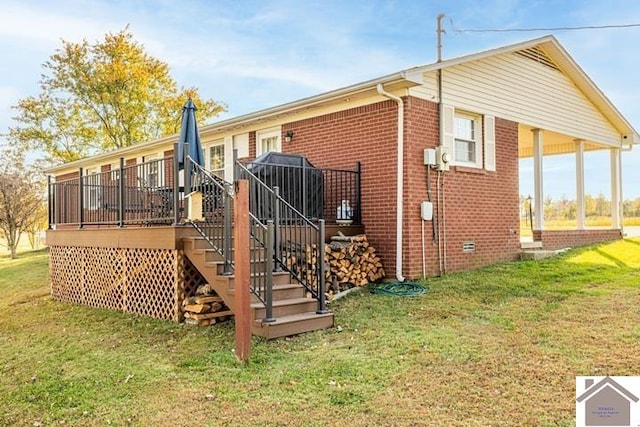 back of house featuring a wooden deck and a lawn