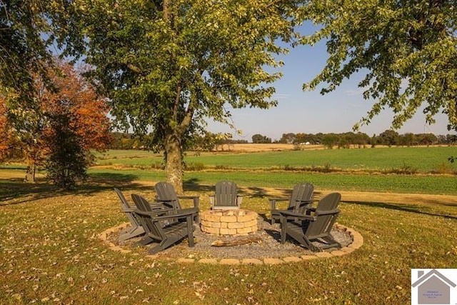 view of yard featuring an outdoor fire pit and a rural view