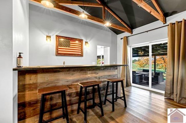 bar with vaulted ceiling with beams and hardwood / wood-style floors