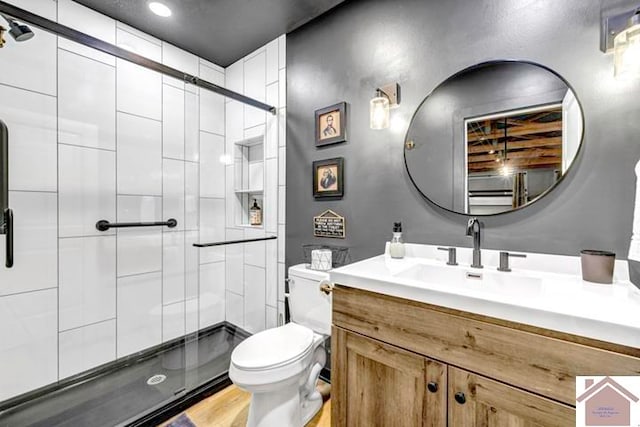 bathroom featuring vanity, toilet, hardwood / wood-style flooring, and walk in shower