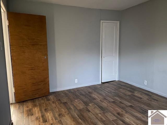 unfurnished bedroom with dark hardwood / wood-style flooring