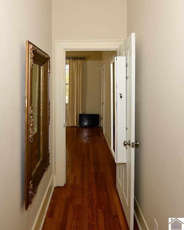 corridor with dark hardwood / wood-style flooring