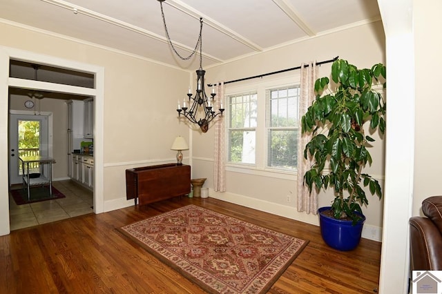 interior space with an inviting chandelier, ornamental molding, and dark wood-type flooring