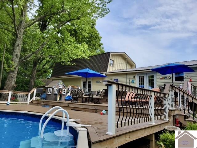 rear view of property featuring a pool side deck