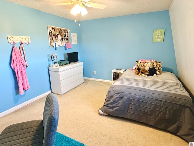 bedroom featuring ceiling fan, light colored carpet, and a textured ceiling