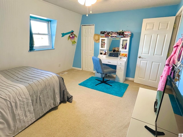 bedroom featuring light carpet and a textured ceiling