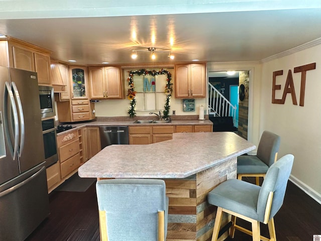 kitchen featuring dark hardwood / wood-style flooring, a breakfast bar, stainless steel appliances, sink, and a center island