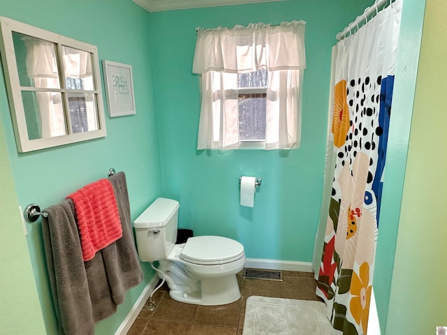 bathroom featuring tile patterned floors, toilet, and walk in shower