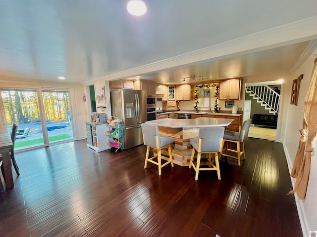 kitchen featuring a kitchen breakfast bar, crown molding, dark hardwood / wood-style floors, a kitchen island, and stainless steel appliances