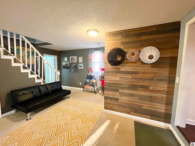 interior space with carpet flooring, wood walls, and a textured ceiling