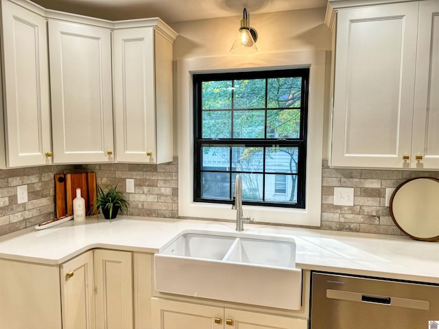 kitchen featuring backsplash, dishwasher, white cabinets, and sink