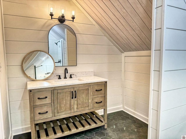 bathroom with wooden walls, vanity, and vaulted ceiling