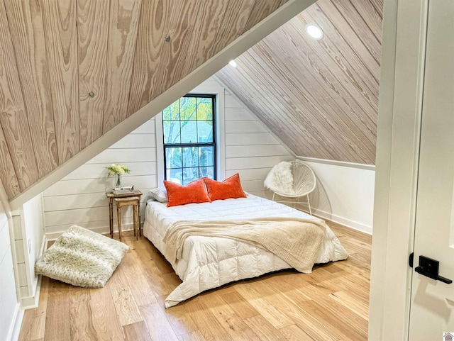 bedroom with wooden walls, vaulted ceiling, and hardwood / wood-style flooring