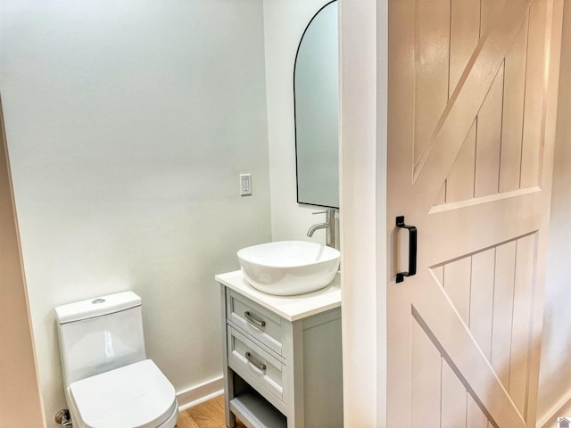 bathroom featuring hardwood / wood-style floors, vanity, and toilet