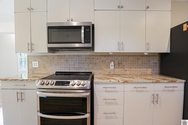 kitchen with decorative backsplash, white cabinetry, light stone countertops, and stainless steel appliances